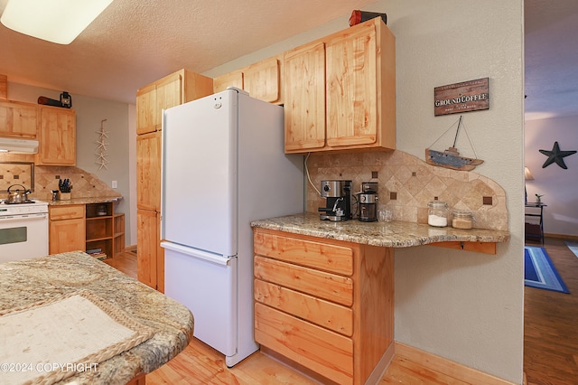 kitchen featuring light hardwood / wood-style floors, white appliances, and light brown cabinetry