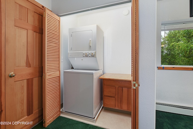 clothes washing area with dark colored carpet, stacked washing maching and dryer, and a baseboard radiator