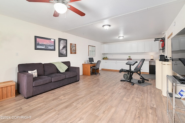 workout room with ceiling fan and light hardwood / wood-style flooring