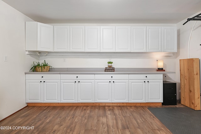 kitchen with dark hardwood / wood-style floors and white cabinetry