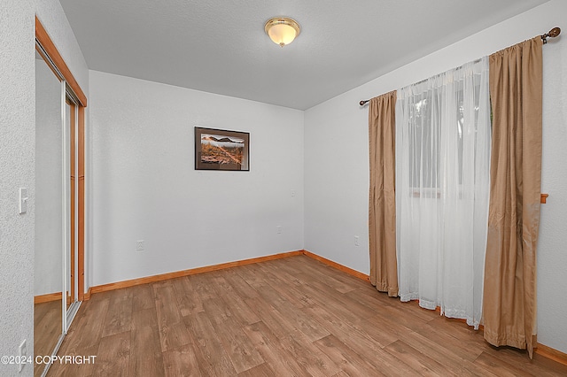 unfurnished bedroom with a closet and light wood-type flooring