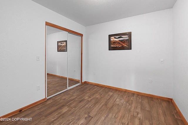 unfurnished bedroom featuring hardwood / wood-style flooring and a closet