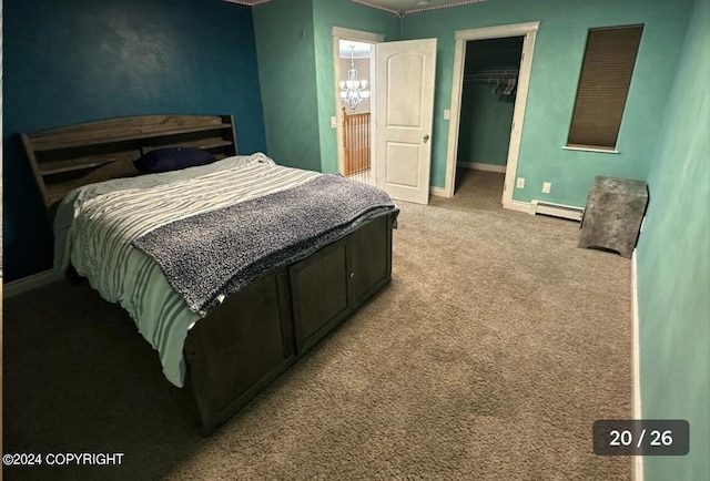 bedroom with baseboards, carpet floors, a closet, a baseboard heating unit, and a walk in closet