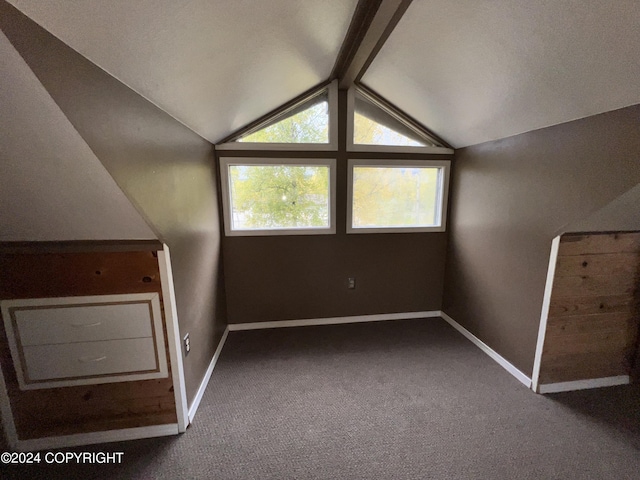 bonus room featuring lofted ceiling with beams, baseboards, and carpet
