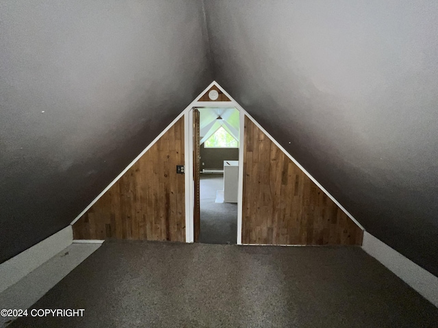 bonus room with lofted ceiling, wooden walls, and carpet