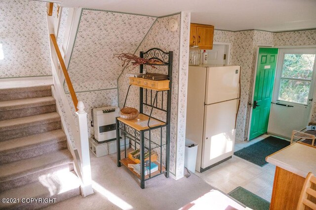 kitchen featuring heating unit and white fridge