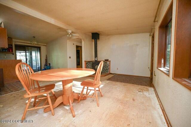 dining area with a wood stove and ceiling fan