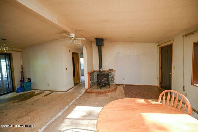 dining room with a wood stove and ceiling fan