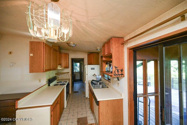 kitchen with a healthy amount of sunlight, sink, white appliances, and a chandelier