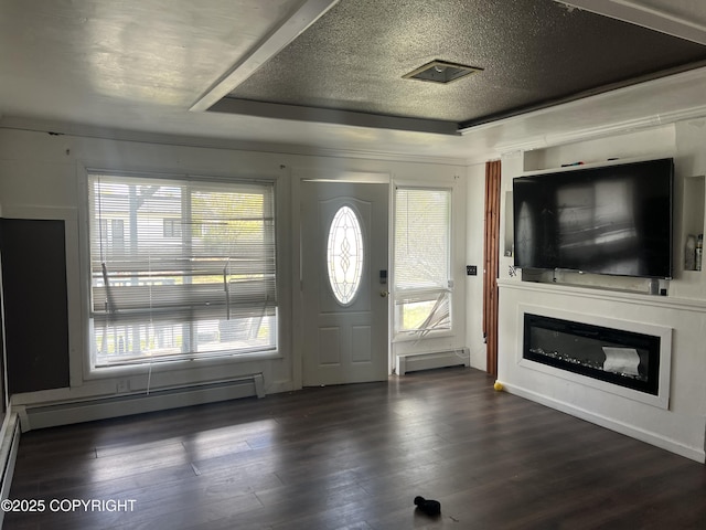 foyer with a baseboard heating unit, baseboard heating, plenty of natural light, and a textured ceiling