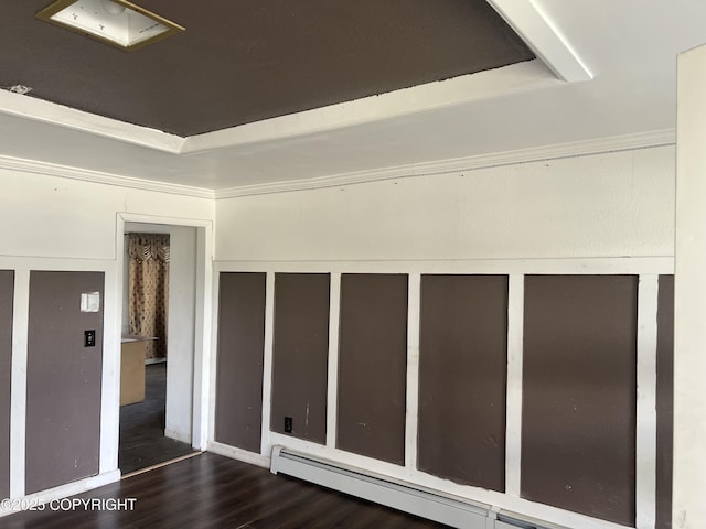 spare room featuring baseboard heating and wood finished floors