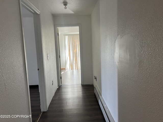 hallway featuring a textured wall, a baseboard radiator, and dark wood finished floors