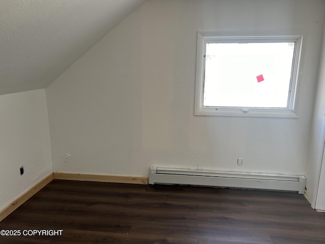 additional living space with vaulted ceiling, a baseboard radiator, dark wood finished floors, and baseboards