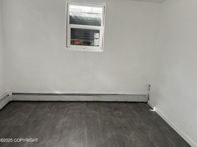 unfurnished room featuring baseboard heating, dark wood-style flooring, and baseboards