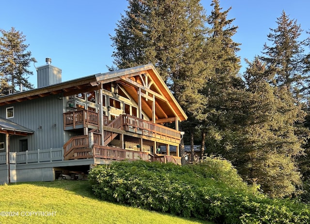 345 C St, Seldovia, AK 99663 - back of property featuring a lawn, a chimney, and a wooden deck