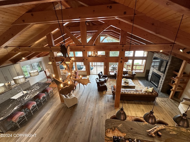 345 C St, Seldovia, AK 99663 - living area with high vaulted ceiling, wooden ceiling, wood-type flooring, a stone fireplace, and beamed ceiling