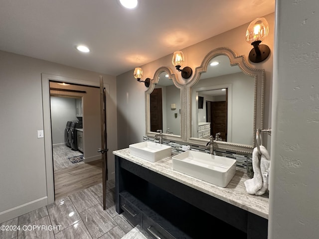 345 C St, Seldovia, AK 99663 - bathroom featuring double vanity, washer and dryer, a sink, and tasteful backsplash