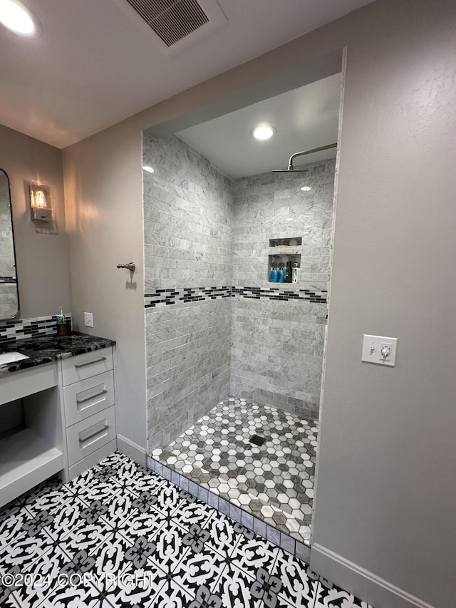345 C St, Seldovia, AK 99663 - bathroom featuring baseboards, visible vents, tiled shower, and vanity