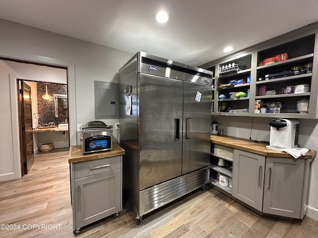 345 C St, Seldovia, AK 99663 - interior space with stainless steel built in refrigerator, electric panel, wood counters, light wood-type flooring, and gray cabinets