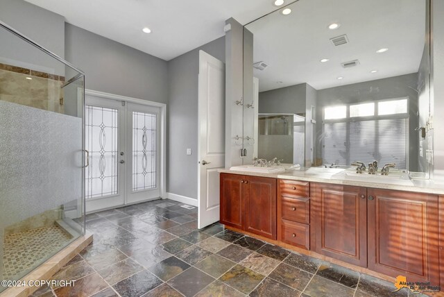 8100 Sky Mountain Ln, Anchorage, AK 99502 - full bath with french doors, stone tile floors, a stall shower, double vanity, and baseboards