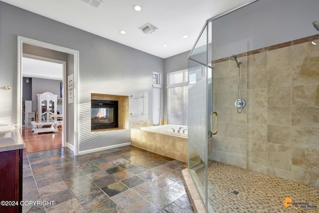8100 Sky Mountain Ln, Anchorage, AK 99502 - full bathroom with a bath, a stall shower, stone tile floors, vanity, and baseboards