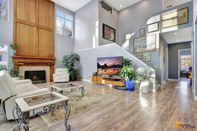 8100 Sky Mountain Ln, Anchorage, AK 99502 - living room with a high ceiling, baseboards, wood finished floors, and a tile fireplace