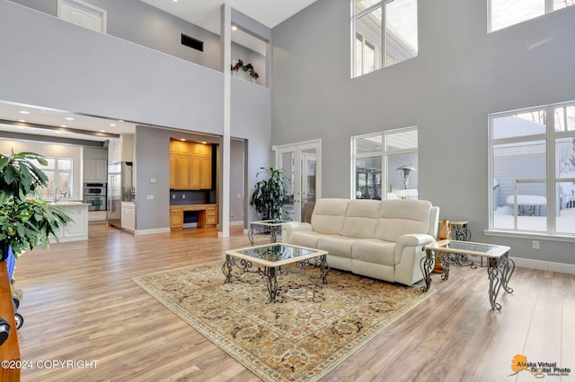 8100 Sky Mountain Ln, Anchorage, AK 99502 - living area featuring a towering ceiling, light wood-style floors, and baseboards