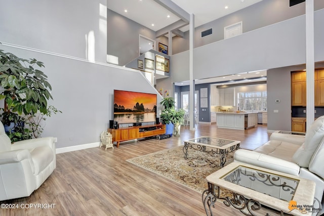 8100 Sky Mountain Ln, Anchorage, AK 99502 - living area featuring light wood-style flooring, a high ceiling, baseboards, and recessed lighting