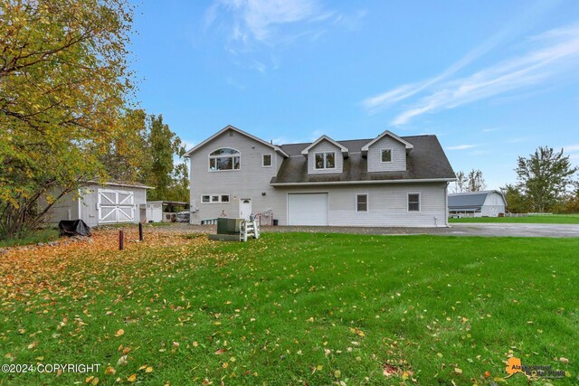 exterior space with a garage, a storage unit, and a front lawn