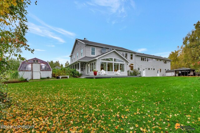 rear view of house with a garage and a yard