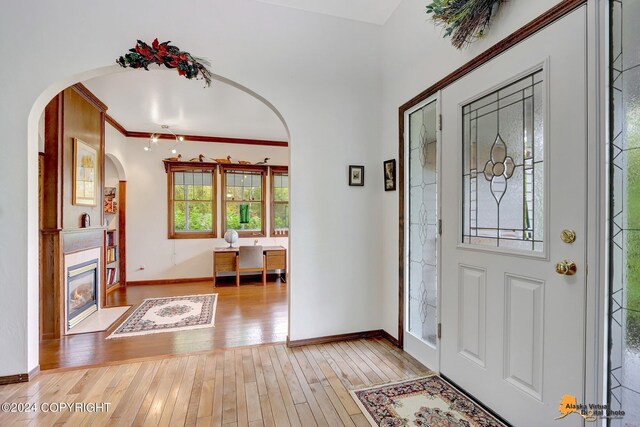 entrance foyer featuring crown molding and light hardwood / wood-style flooring