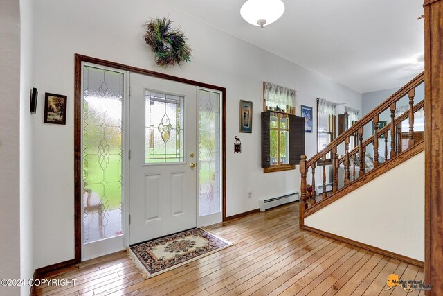 foyer with a baseboard heating unit and light wood-type flooring