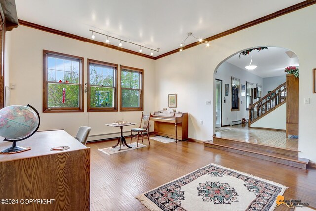 office area featuring rail lighting, ornamental molding, baseboard heating, and hardwood / wood-style flooring