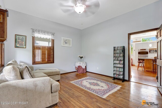 living room featuring ceiling fan and light hardwood / wood-style floors