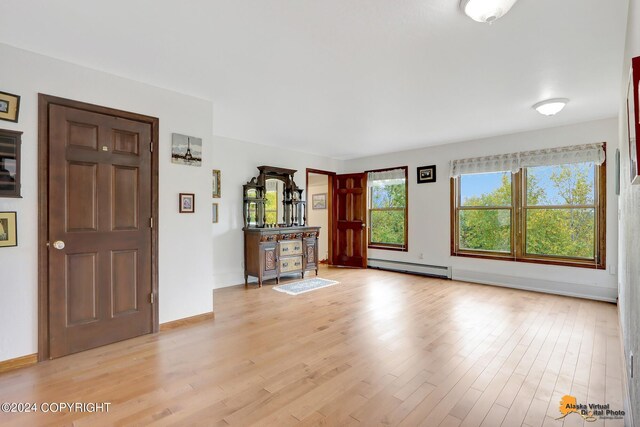 entryway featuring light hardwood / wood-style floors, bar area, and a baseboard radiator