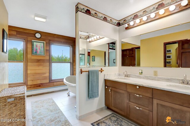 bathroom featuring vanity, wooden walls, a tub to relax in, and baseboard heating