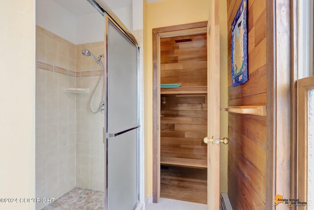 bathroom featuring tile patterned flooring and an enclosed shower