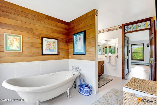 bathroom featuring a bath, wood walls, and vanity
