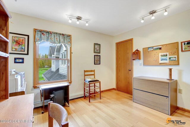 living area with light hardwood / wood-style flooring and a baseboard radiator