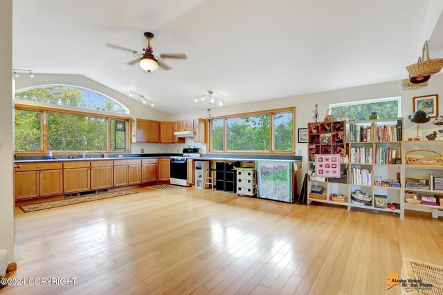 kitchen featuring ceiling fan, light hardwood / wood-style floors, white range, and vaulted ceiling