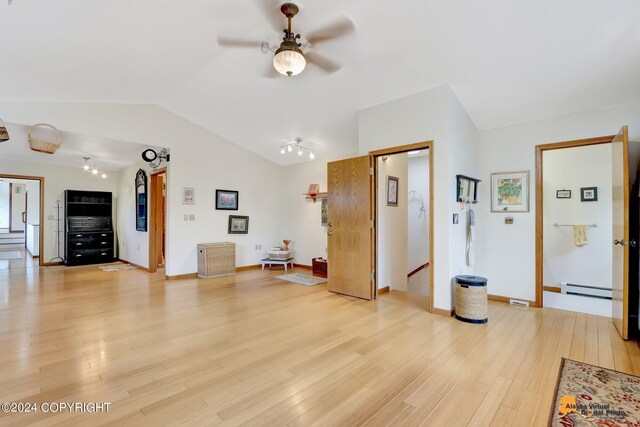 living room with lofted ceiling, ceiling fan, a baseboard heating unit, and light hardwood / wood-style flooring