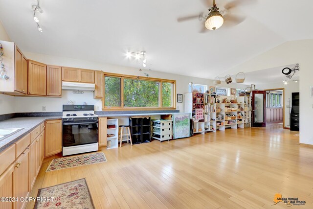 kitchen featuring light hardwood / wood-style floors, white gas stove, vaulted ceiling, light brown cabinets, and ceiling fan