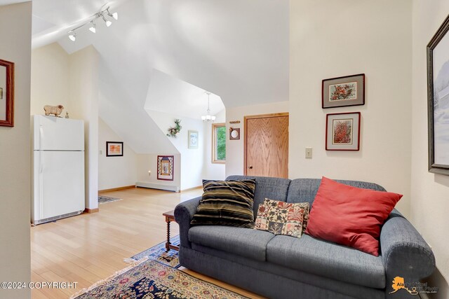 living room featuring track lighting, baseboard heating, light hardwood / wood-style floors, and high vaulted ceiling