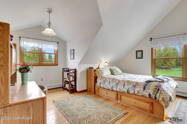 bedroom featuring a baseboard heating unit, light wood-type flooring, lofted ceiling, and multiple windows
