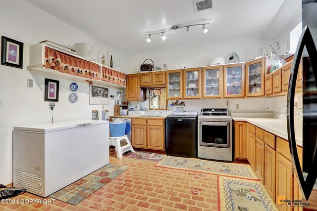 kitchen featuring black refrigerator, refrigerator, and separate washer and dryer