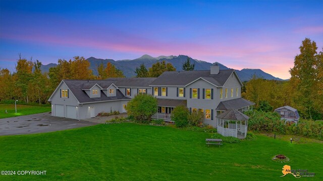 view of front of property with a mountain view, a yard, and a garage