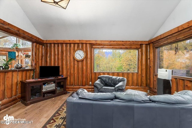 living room with wood-type flooring, vaulted ceiling, and wood walls