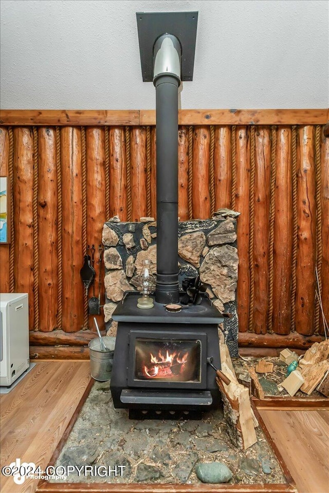 details featuring a wood stove and wood-type flooring