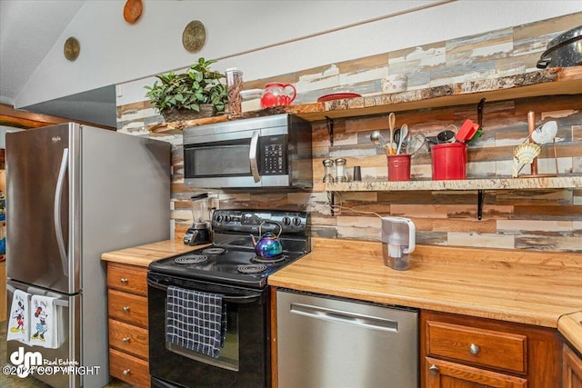 kitchen featuring decorative backsplash, appliances with stainless steel finishes, and wooden counters