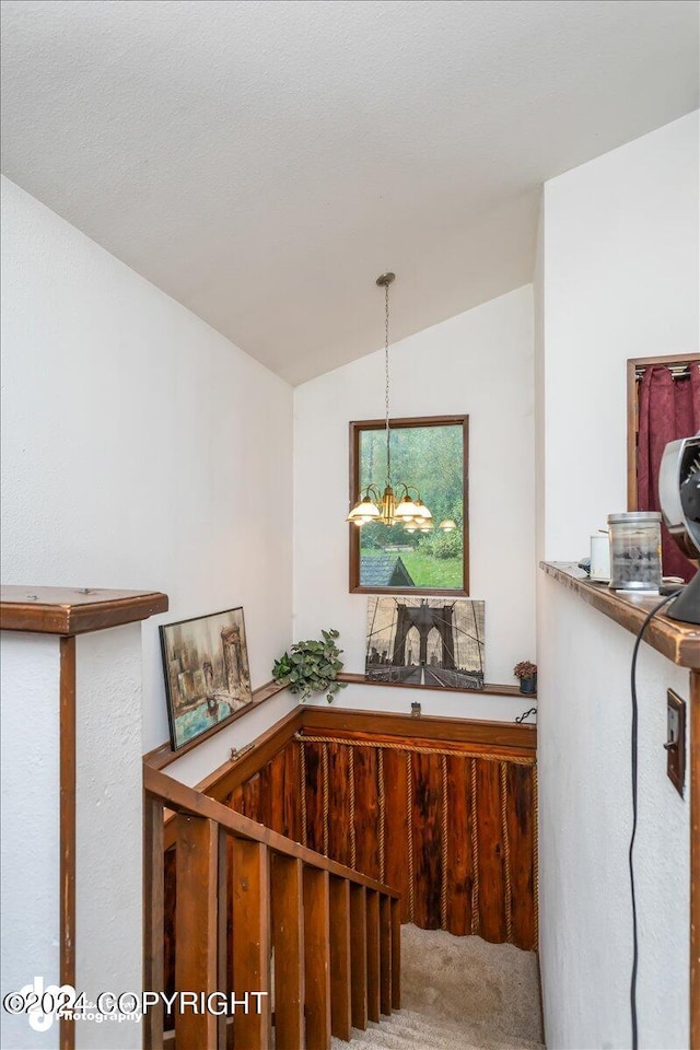 interior space featuring carpet, lofted ceiling, and a chandelier